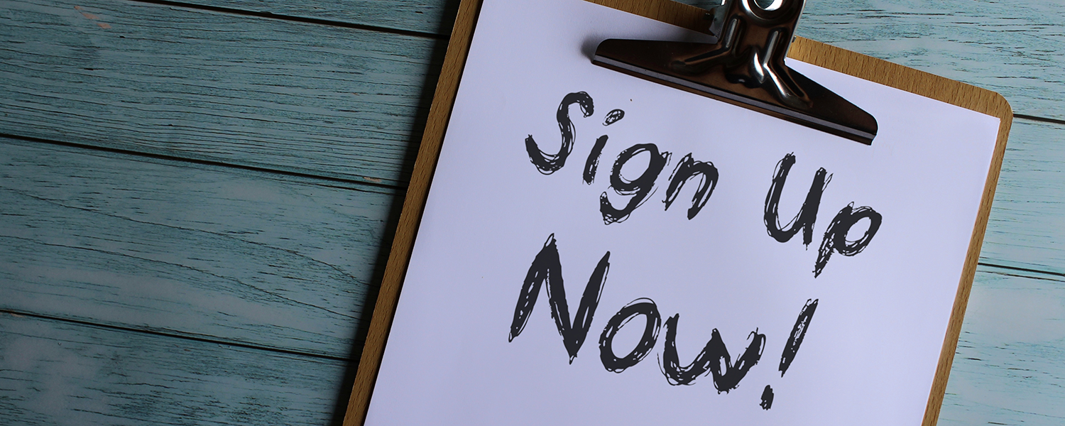 Top view image of paper clipboard with text Sign Up Now!