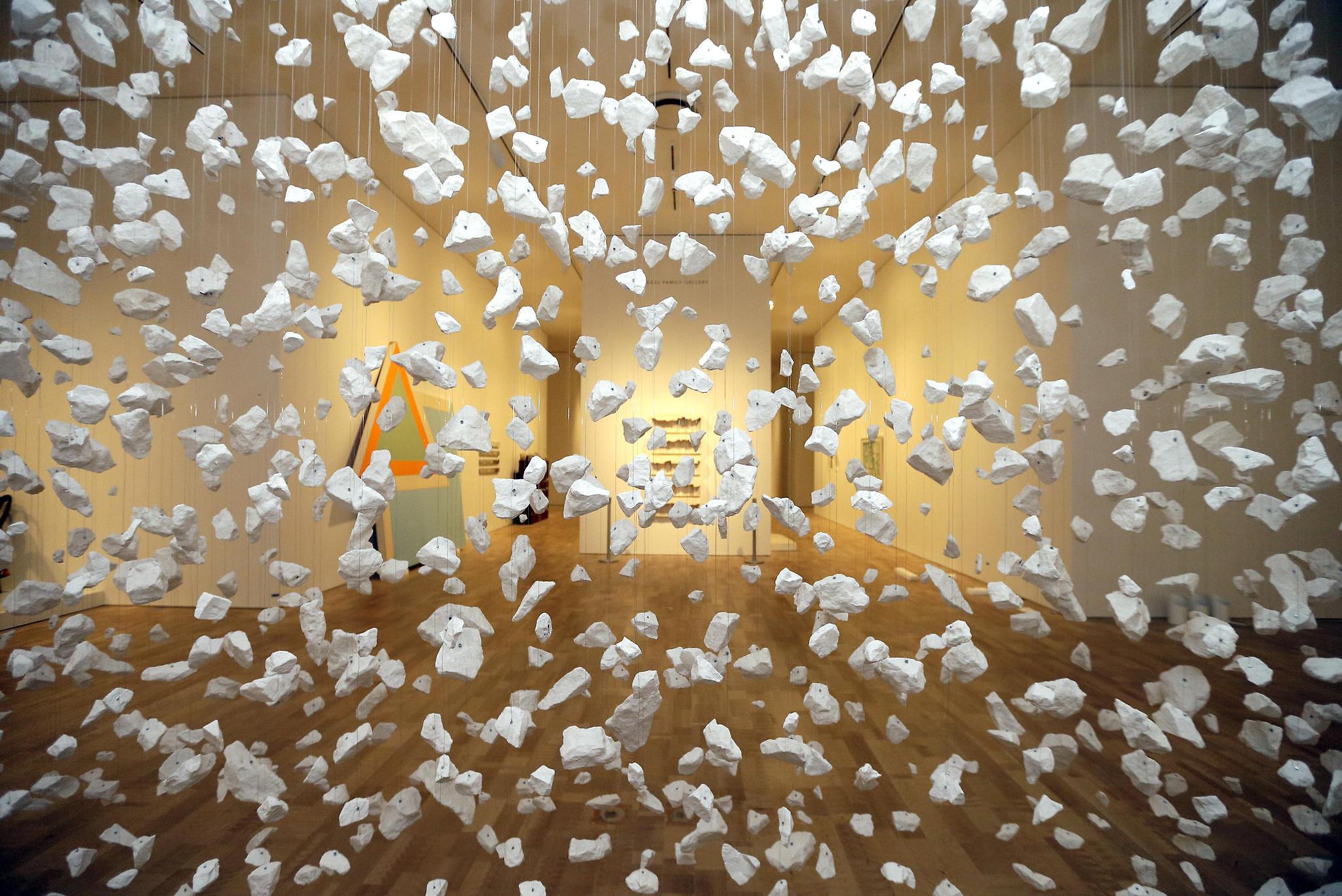 Art piece with suspended stones creating a transparent wall of stones