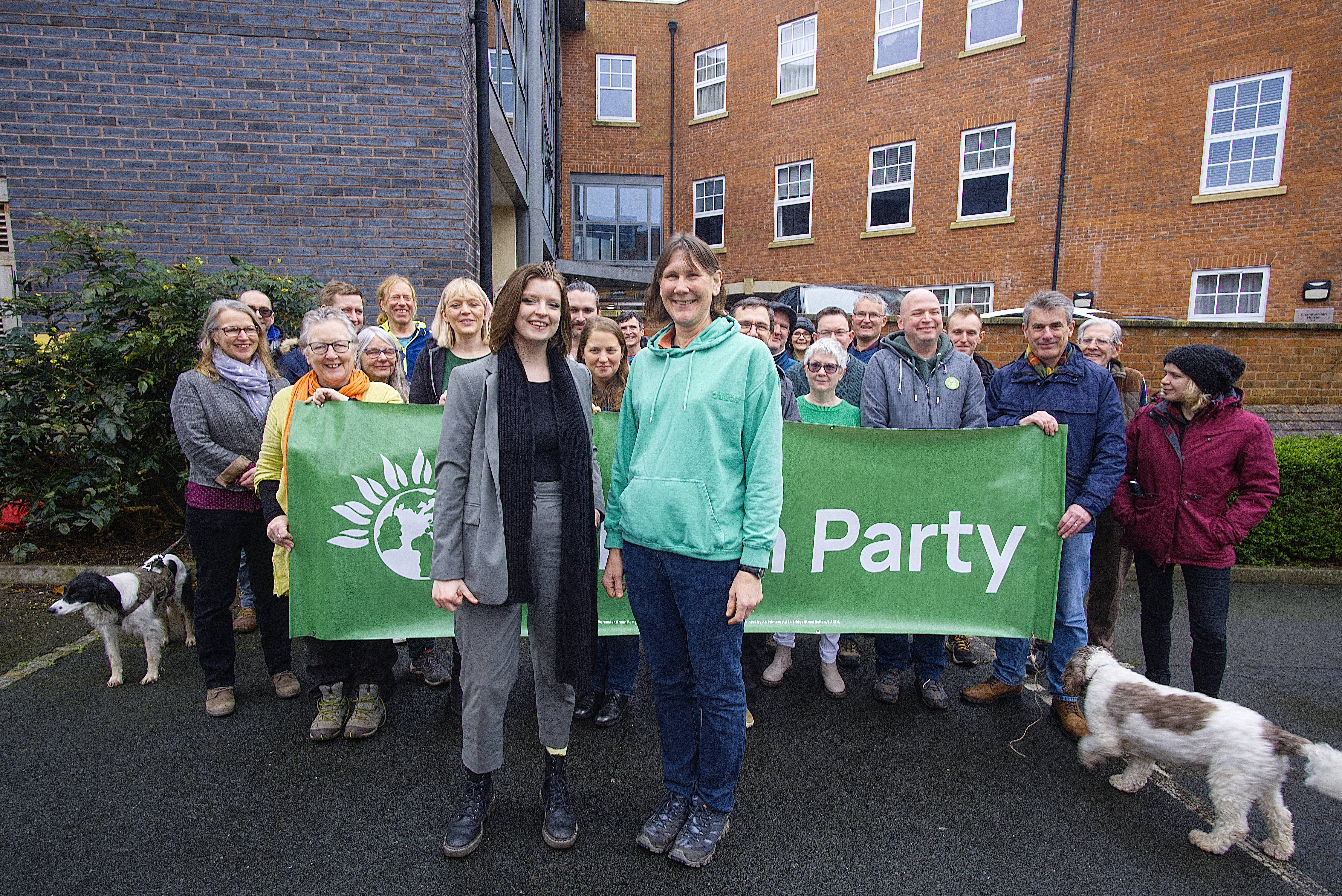 A group of Green Party supports with a "Green Party" banner. Their hands are in the air.
