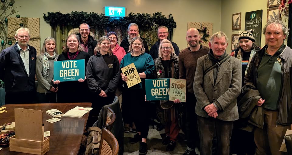 photo of Green members holding signs saying Vote Green