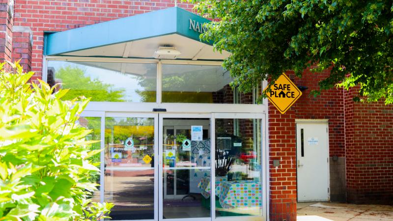 Nannie J. Lee Rec Center entrance: a brick building with glass sliding doors and a green triangular awning