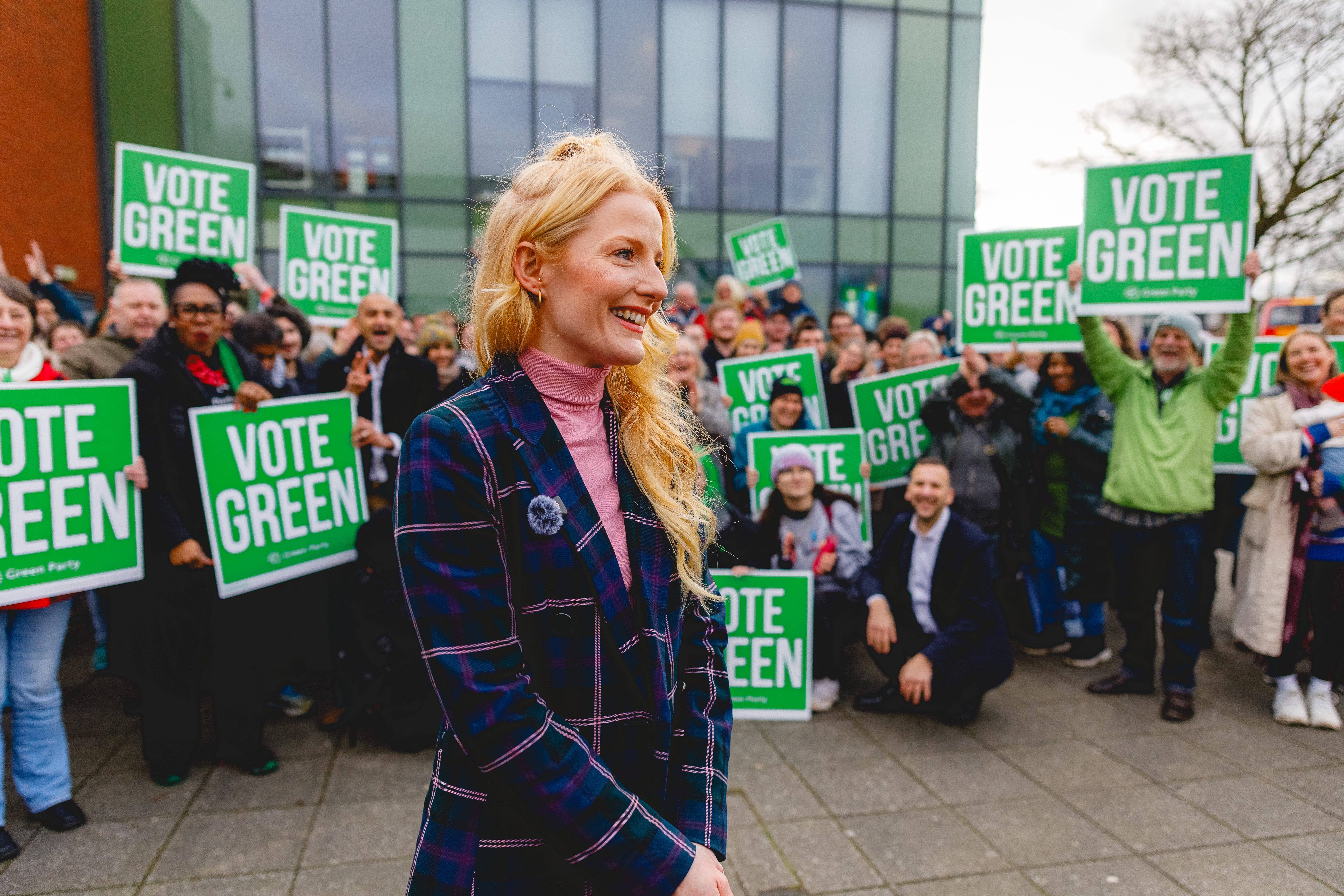 Hannah looking happy in front of a crowd of Green supporters