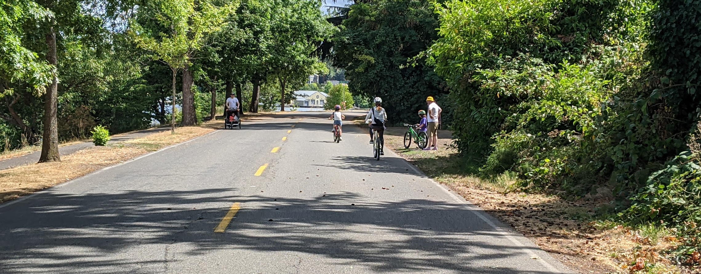 People enjoy bike weekend, a family bikes and a parent pushes a running stroller.