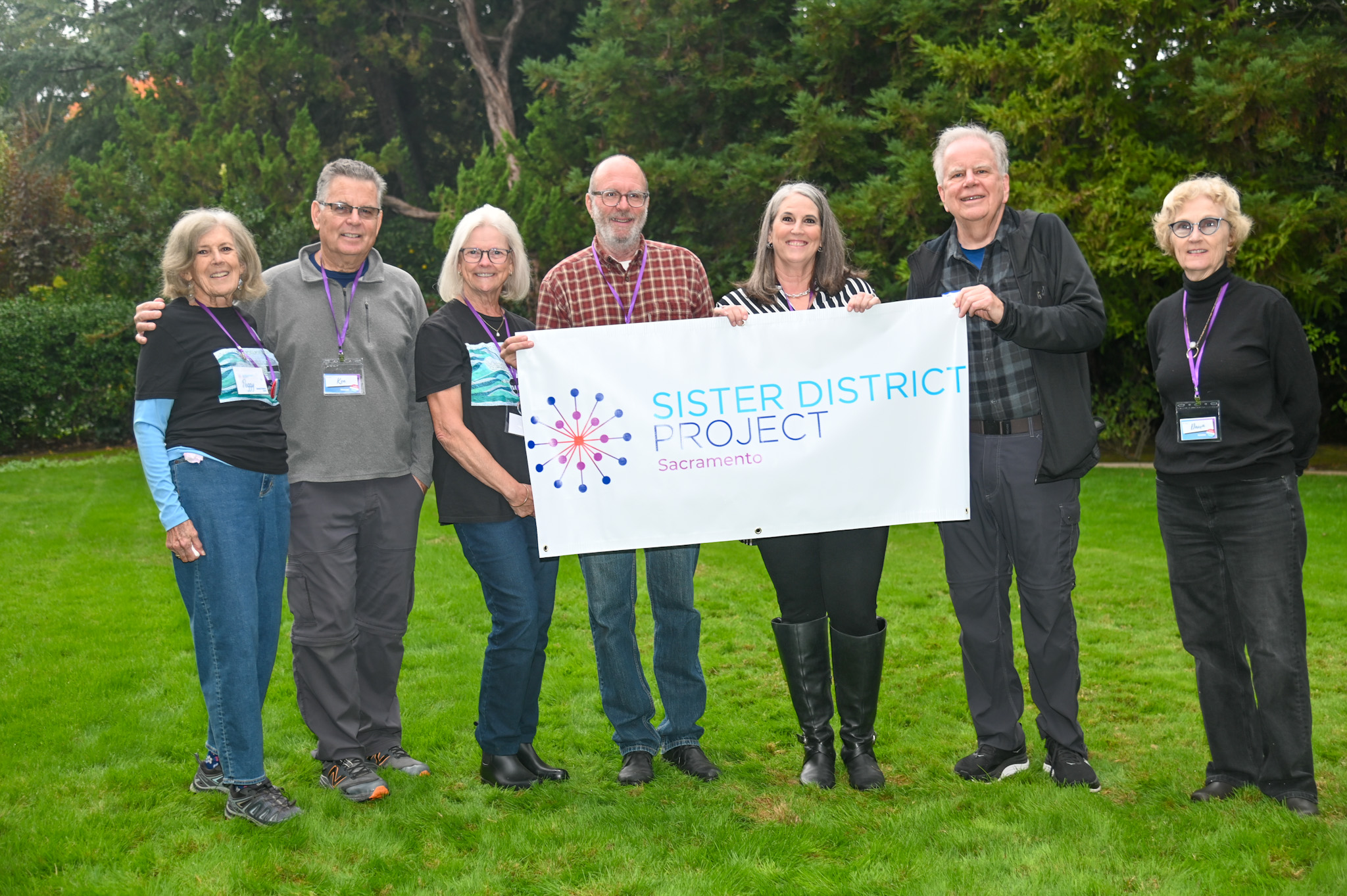 Gallery view of a web conference of 8 volunteer leaders, smiling while facing the camera directly