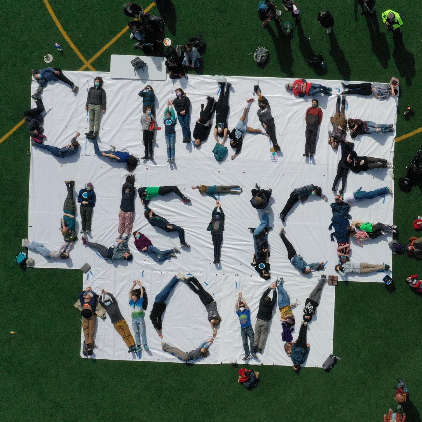 Human Mural that  reads "Climate Justice Now"