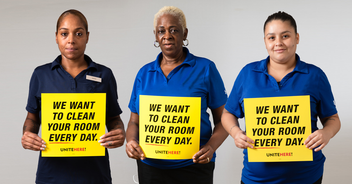 Housekeepers hold signs that say "We want to clean your room every day"