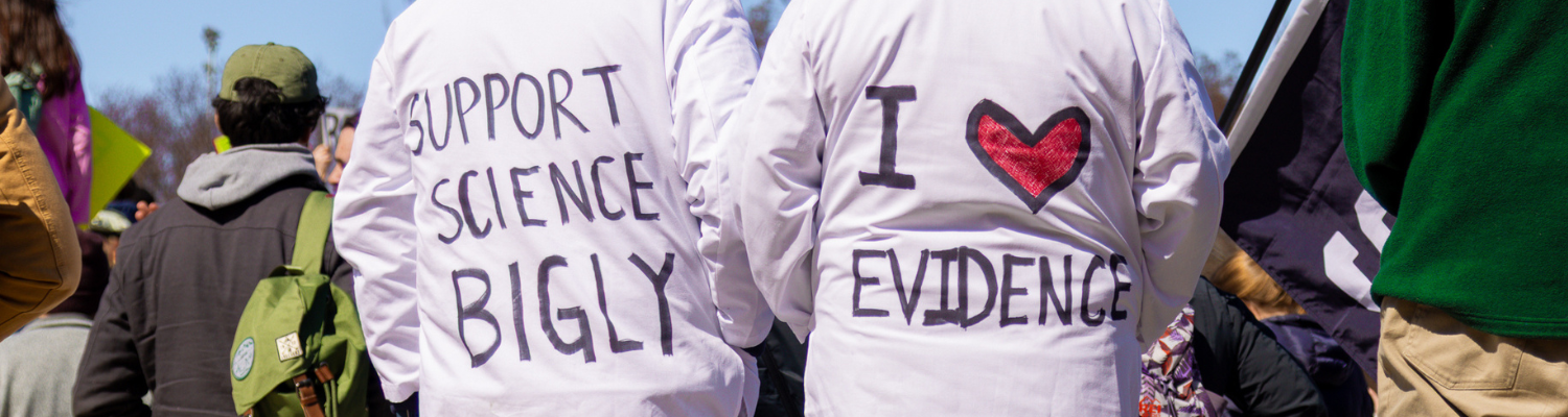 Photo with 2 people in lab coats at a Stand Up For Science rally