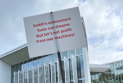 Sign in front of Campus Center reads "Smith's endowment fuels our dreams But let's not profit from war machines!"