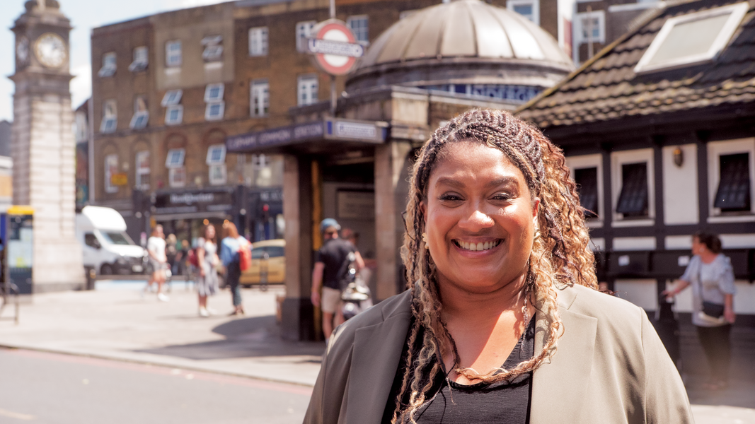 Bell stands smiling in front of Clapham Common Tube Station