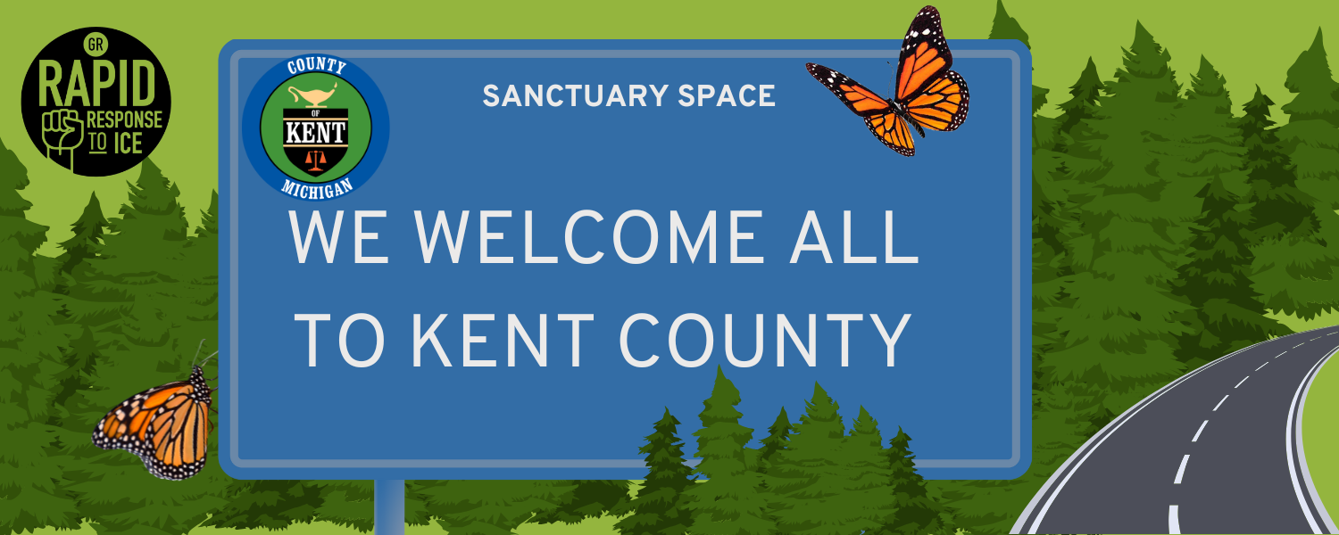 ID: an illustration of a road sign with the logo of Kent County, Michigan on it. The text says "Sanctuary Space: We Welcome All to Kent County." The sign is on a country road winding through pine forests.