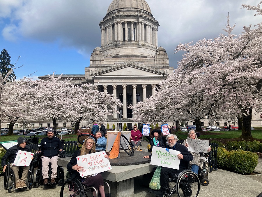 A group of wheelchair users gather in front of the Washington State Capitol