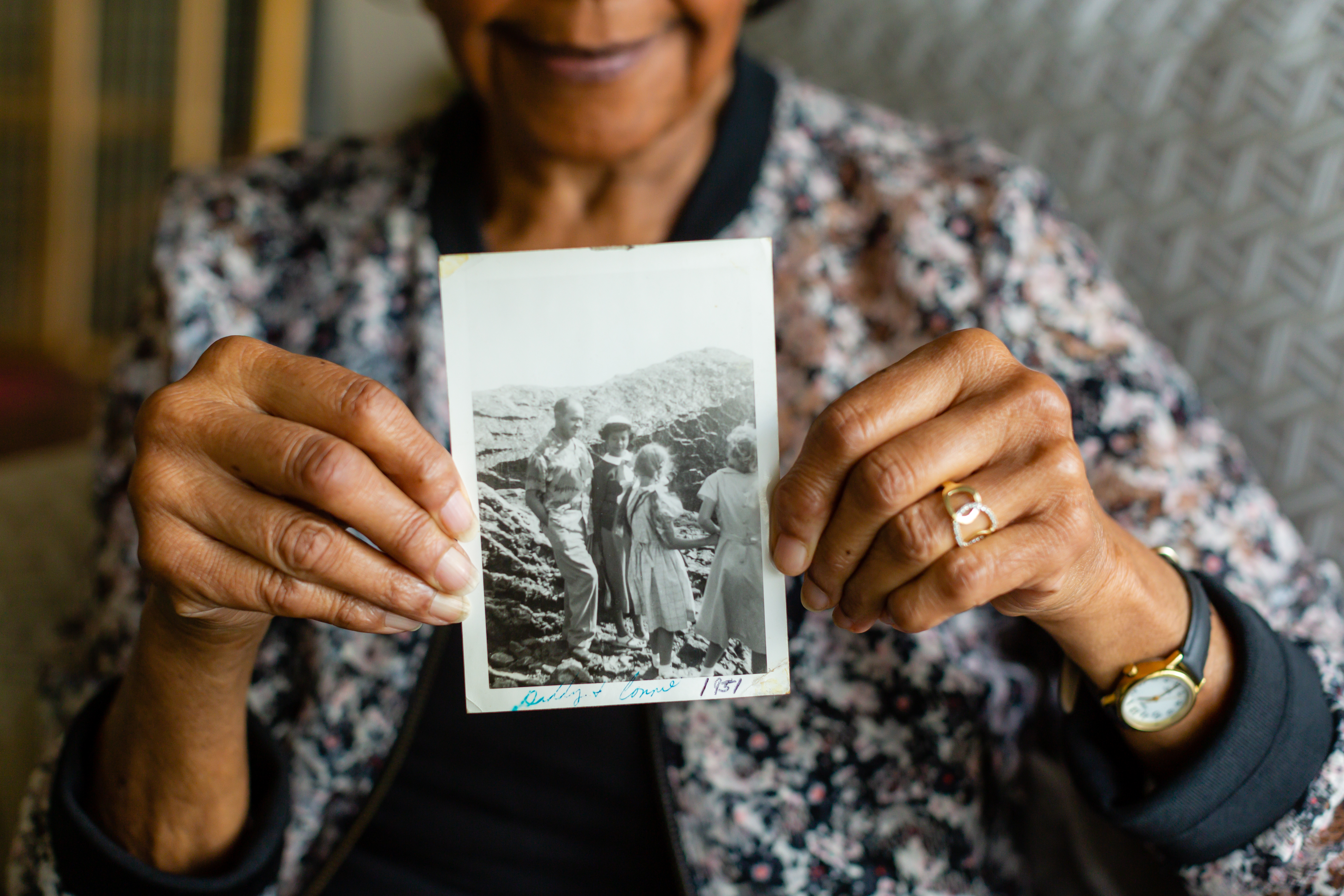 Connie White holding a picture of her and her father, Silas White, at the beach.