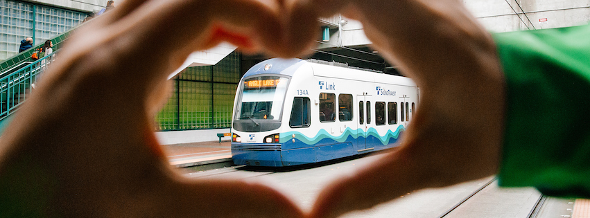Hands forming heart shape centered on Link light rail vehicle