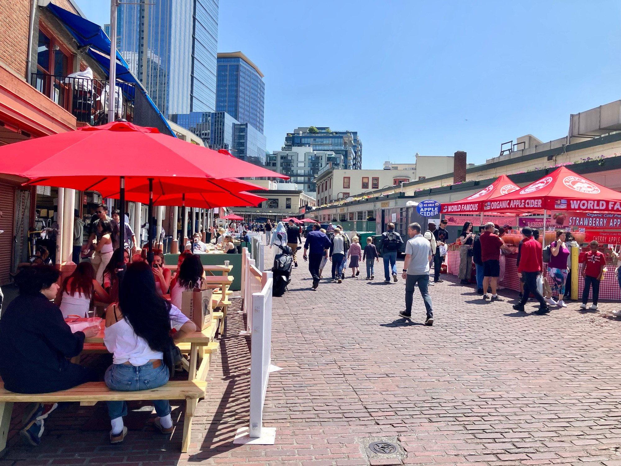 People sitting, walking, eating, vending on the street