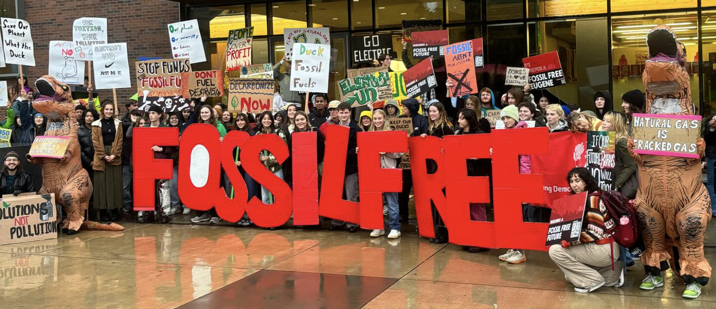 Large group of people holding signs in protest of UO's fossil fuel usage