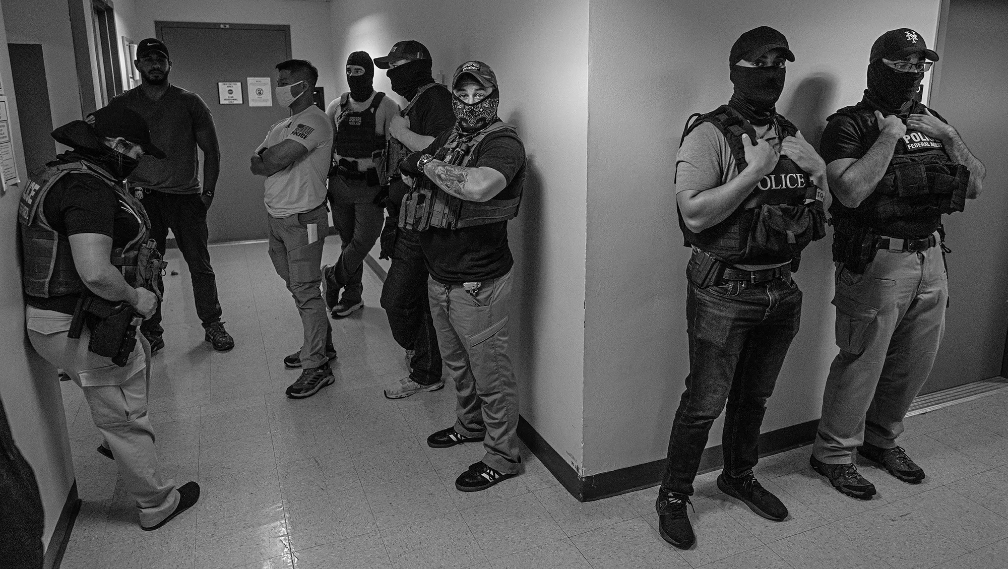 Masked agents line the halls of a courthouse. A Photographer’s View of ICE’s Relentless Courthouse Arrests.