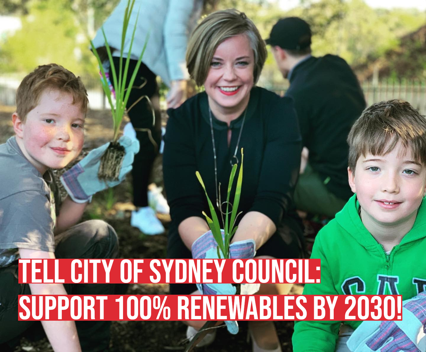Councillor Linda Scott holds a plant, with her sons on either side of her.