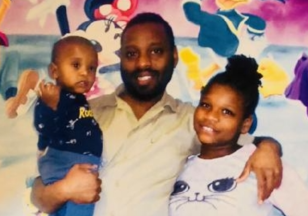 Photo of Garfield holding his son and hugging his daughter