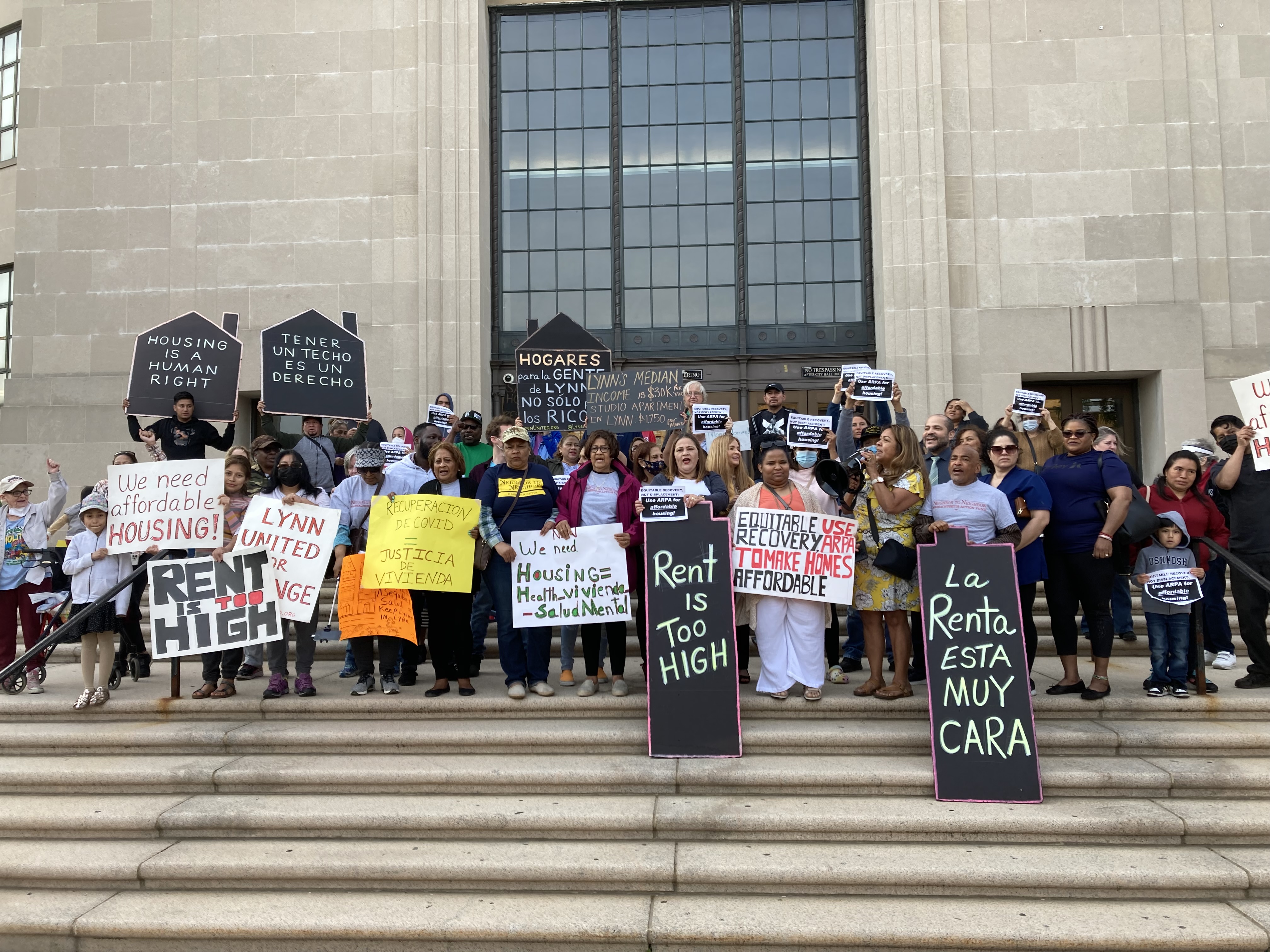 Photo of crowd in front of Lynn City Hall with protest signs calling for affordable housing