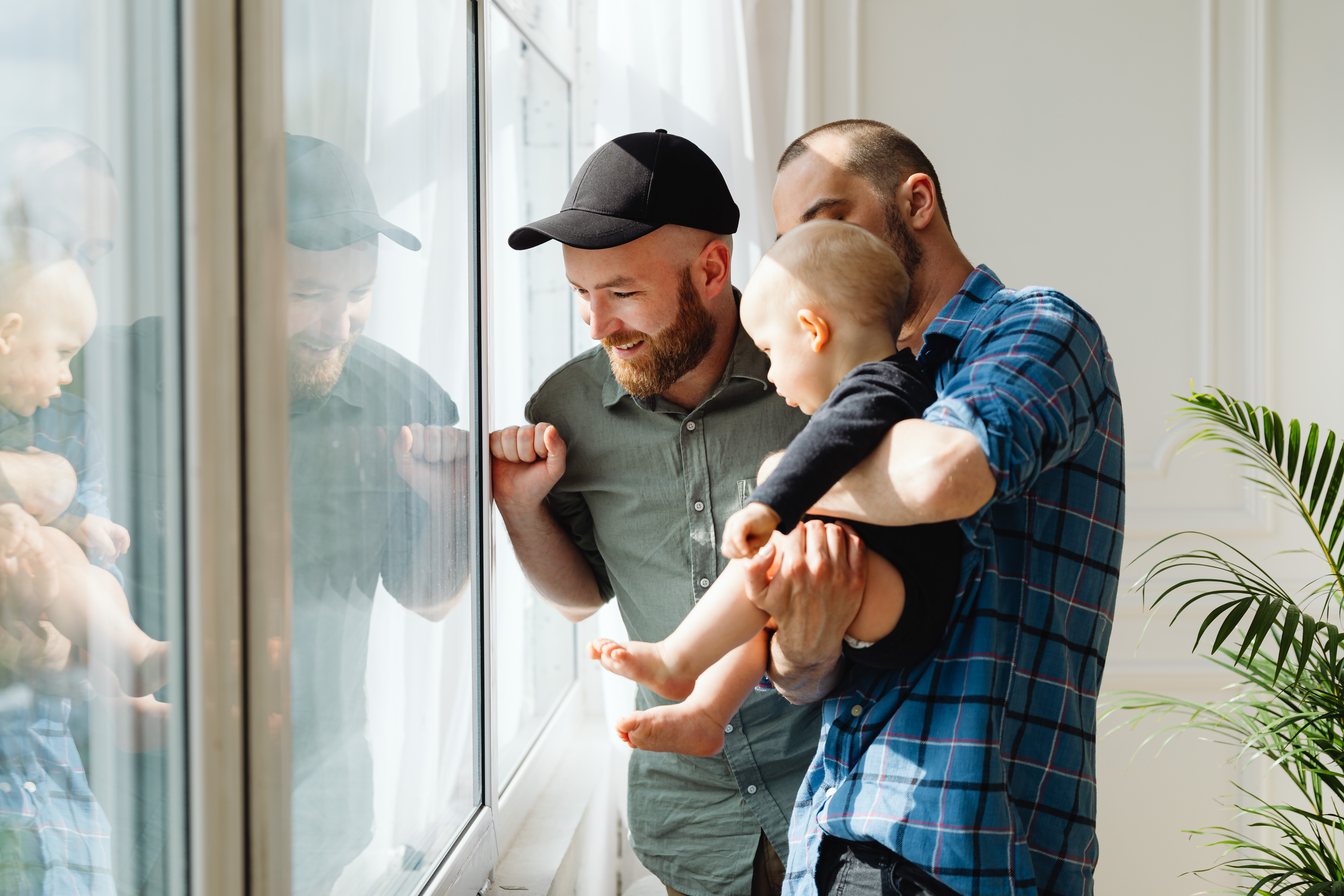 LGBTQ family playing by a window