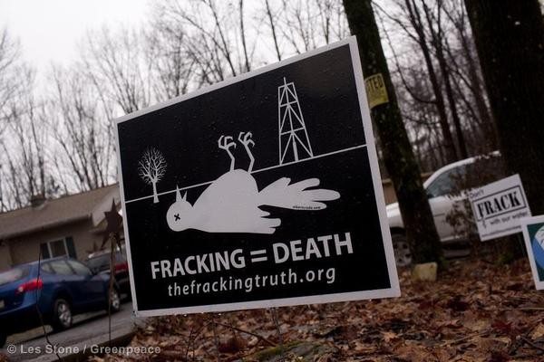 Picture of a dead birth next to a fracking well. The background is black. The bird and fracking well are white. The text in the image reads, "Fracking equals death."