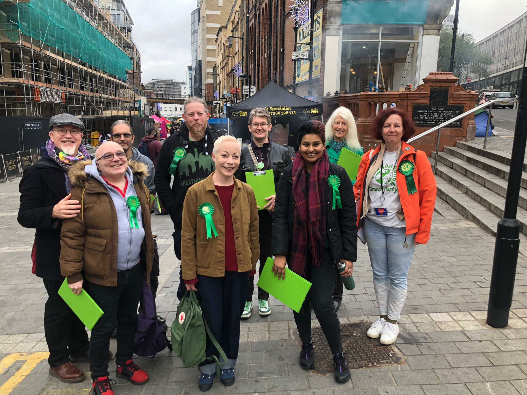 Picture of Green Party members wearing rosettes and carrying clipboards 