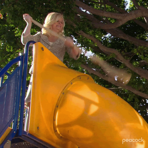 GIF of Leslie Knope with broom sweeping playground slide