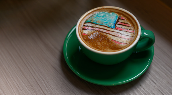 A cup of latte with an American flag design in the foam. | Credit: Chpua / iStock / GettyImages