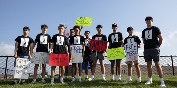 Team of young boys holding signs supporting their friend, who was deported
