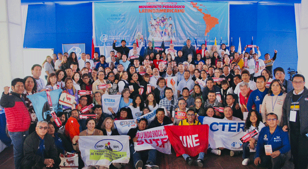 Crowded photo of education unionists posing with signs