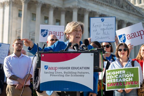 Randi Weingarten speaking in front of the Capitol building with a crowd of people holding signs supporting higher education