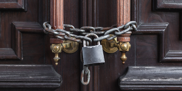A heavy padlock on a heavy door A heavy padlock on a heavy door