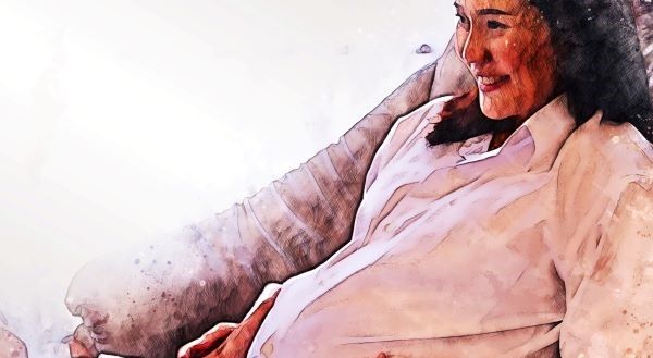 Pregnant woman sitting and smiling Pregnant woman sitting and smiling