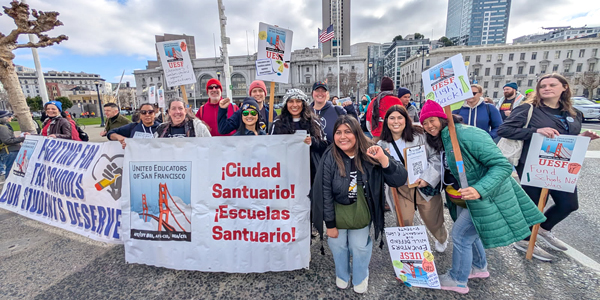 Union members at a rally with a sign that says "Ciudad Sanctuario! Escuelas Sanctuario!"