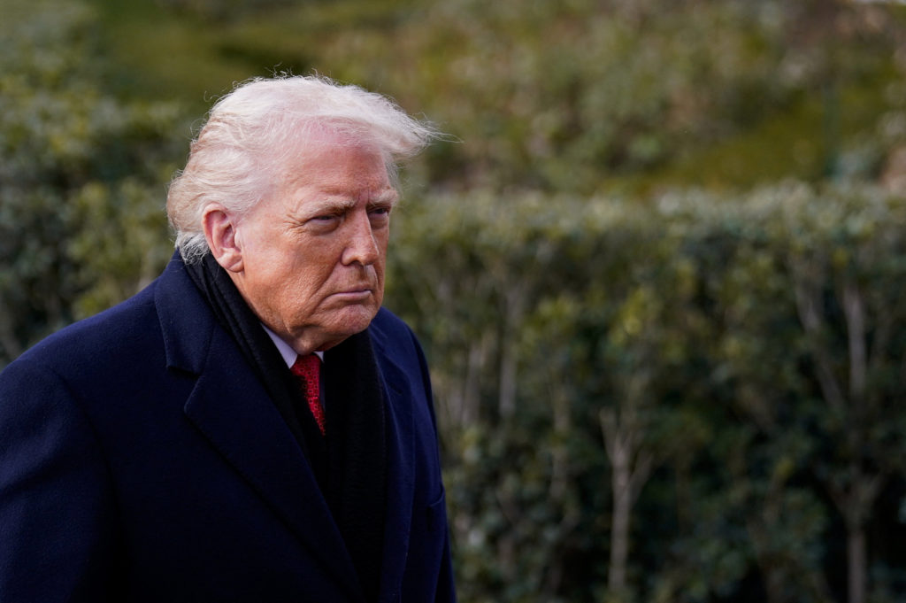 Trump wearing a heavy coat walking outside