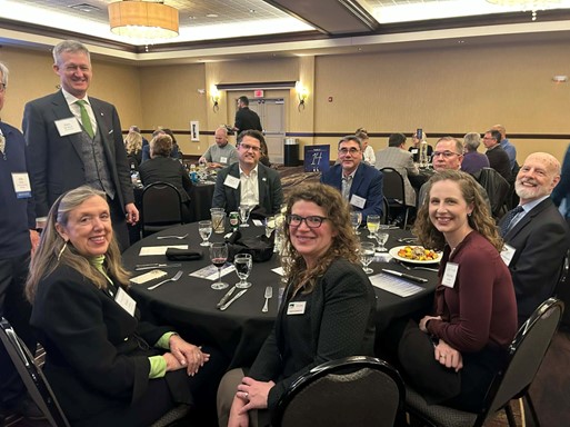 A group of professionals sitting around a dinner table at the Clive Chamber Annual Dinner.
