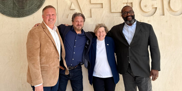 AFT leaders stand together against a wall. 