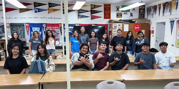 A classroom of students pose for a photo.