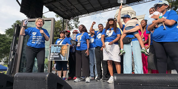 A group of protesters rally together on stage. 