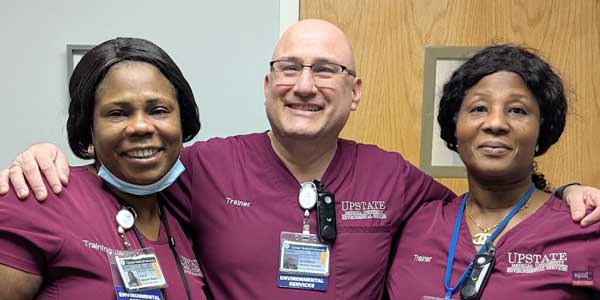 Three nurses stand together smiling. 