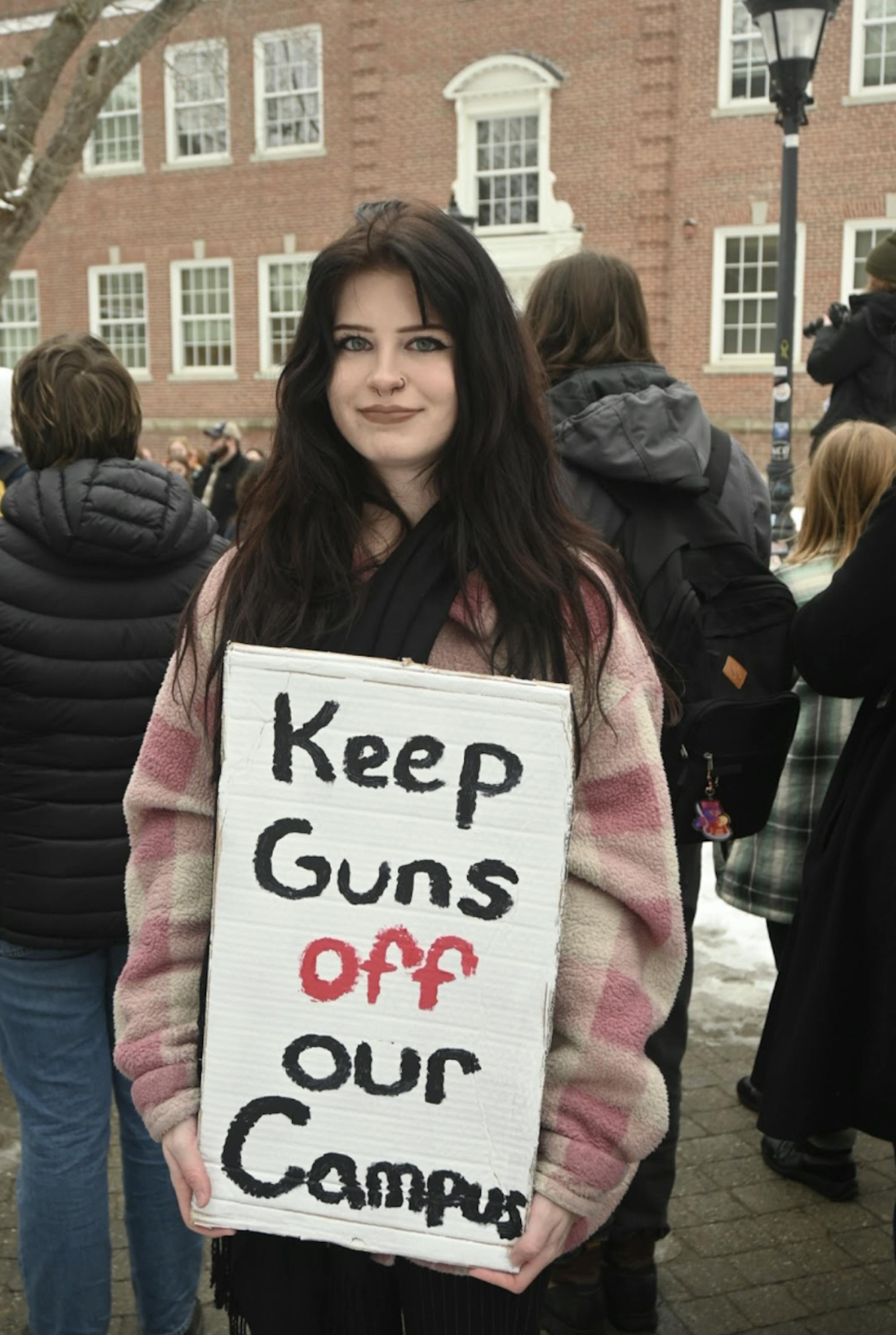 Student holding a Keep Guns Off Our Campus sign