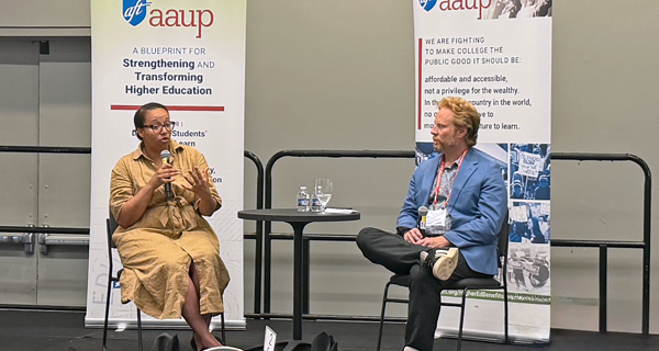Two speakers sit on a stage, talking about organizing to protect academic freedom. Two speakers sit on a stage, talking about organizing to protect academic freedom.