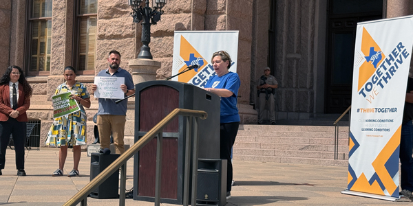 A woman speaks outside at a podium. A woman speaks outside at a podium.
